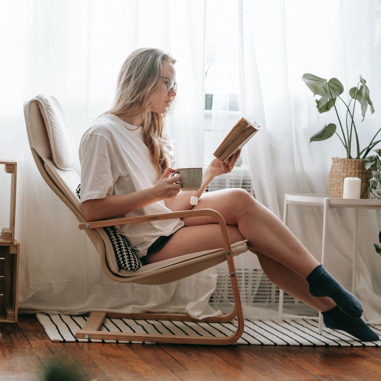 Soluciones para el hogar. Instalaciones de calefacción de gas Silvan Gas mujer leyendo cómodamente en una mecedora gracias a la calefacción de gas de Silvan Gas